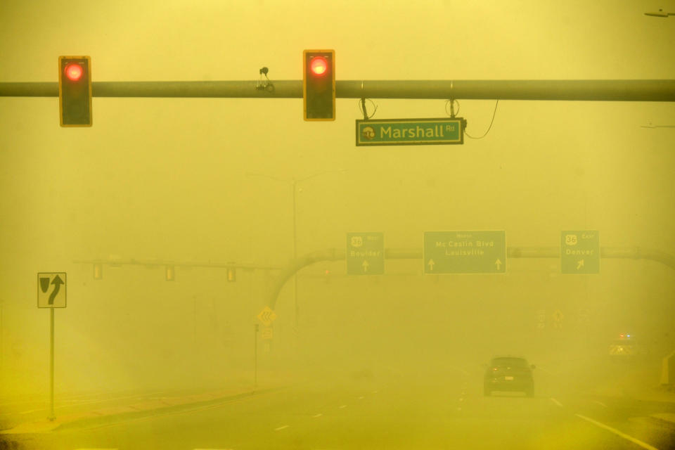 A car makes its way down Colorado's McCaslin Blvd. amid a smoky, yellow sky. (Denver Post via Getty Images)