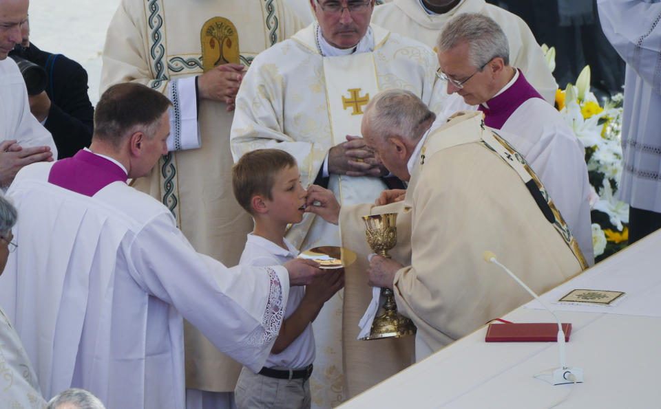 Pope Francis gives the holy communion during the canonization mass for ten new saints in St. Peter's Square at The Vatican, Sunday, May 15, 2022. Francis created ten new saints on Sunday, rallying from knee pain that has forced him to use a wheelchair to preside over the first canonization ceremony at the Vatican in over two years. (AP Photo/Gregorio Borgia)