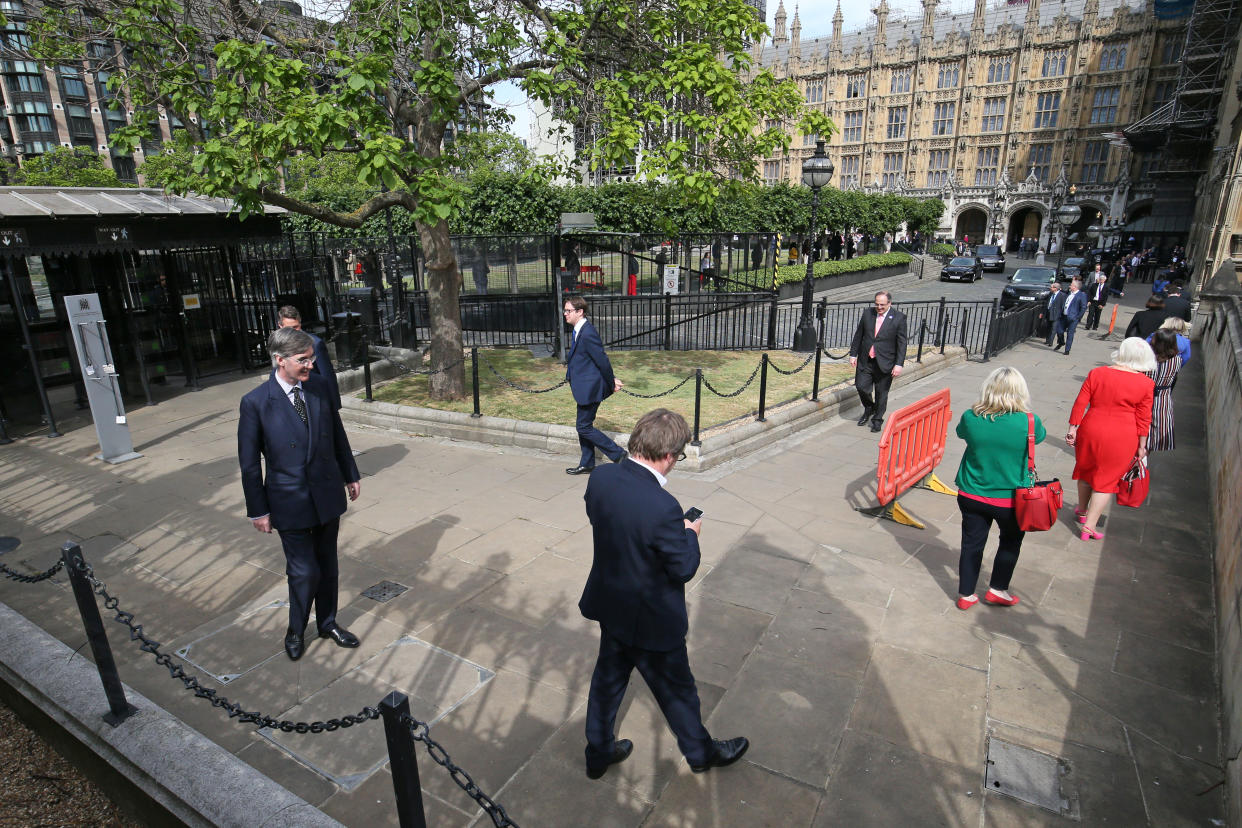 Members of Parliament, including Leader of the House of Commons Jacob Rees-Mogg, queue outside the House of Commons in Westminster, London, as they wait to vote on the future of proceedings, amid a row over how Commons business can take place safely. (Photo by Jonathan Brady/PA Images via Getty Images)