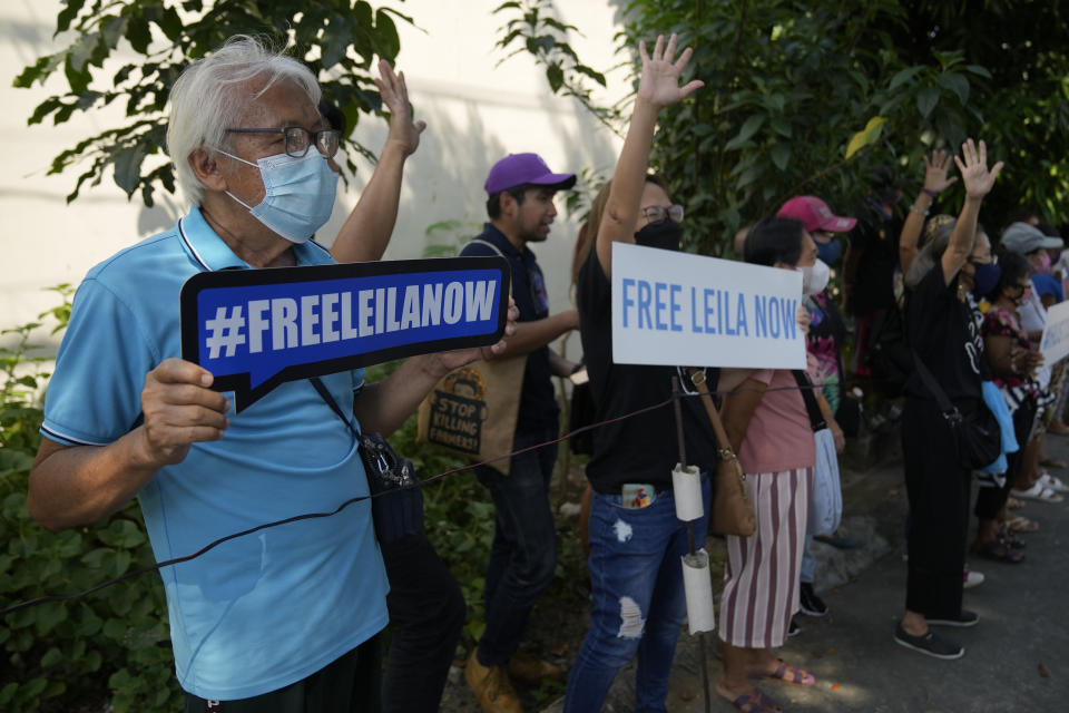 Supporters of detained former opposition Sen. Leila de Lima holds slogans as they wait for her to pass by in Muntinlupa, Philippines, Monday, Oct. 10, 2022. Human rights activists pressed their call Monday for the immediate release of de Lima after she was taken hostage in a rampage by three Muslim militants in a failed attempt to escape from a maximum-security jail. (AP Photo/Aaron Favila)