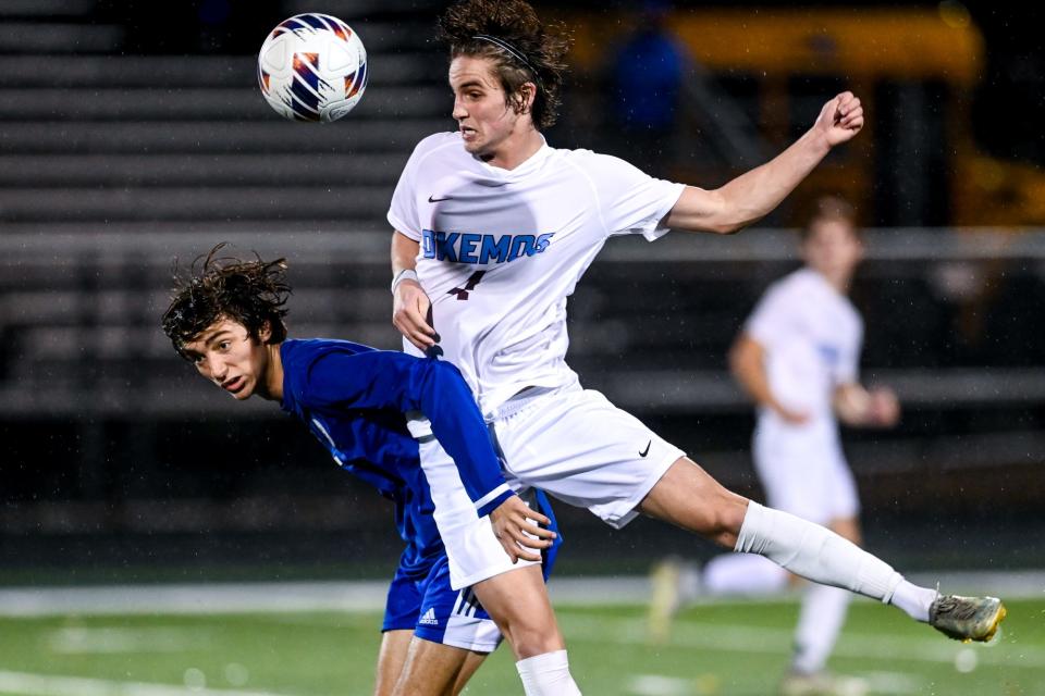 Okemos' Charlie Stover, right, makes a play on the ball over Detroit Catholic Central's Lefteri Theodorou during the first half of overtime on Tuesday, Oct. 25, 2022, at East Lansing High School.