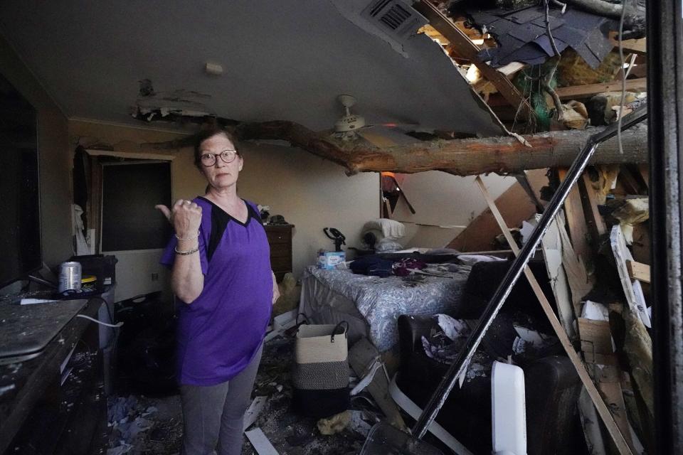 Kathy Barlow jokes that perhaps the tree that crashed through the roof might be holding up the ceiling in the master bedroom of her Rolling Fork, Miss., home, Saturday, March 25, 2023. A tornado damaged much of the rural Mississippi Delta community. (AP Photo/Rogelio V. Solis)