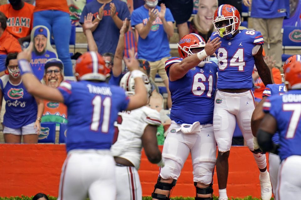 Florida tight end Kyle Pitts (84) celebrates his touchdown catch from quarterback Kyle Trask (11) with offensive lineman Brett Heggie (61) during the first half against South Carolina. (AP)