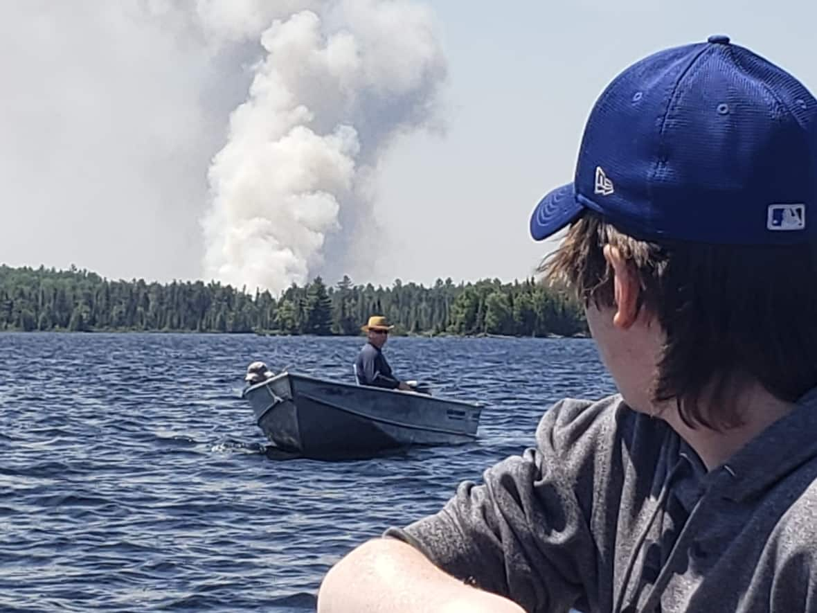 Visitors to Domaine Stoddart took photos of the smoke rising from the forest beyond the shoreline of Lac Nilgaut, Que. (Submitted - image credit)