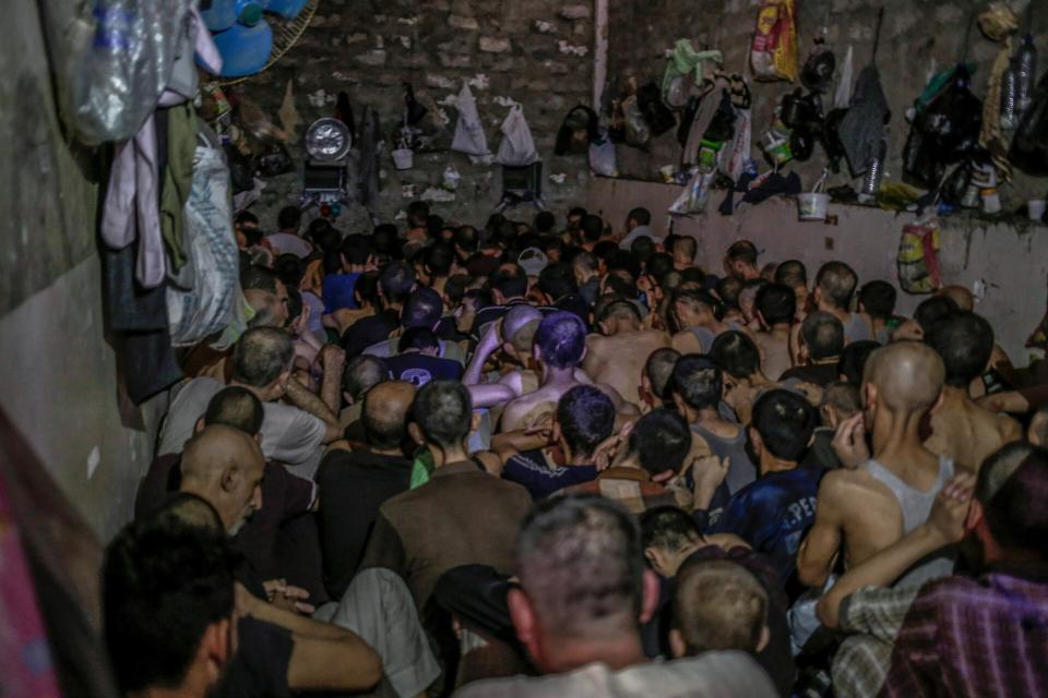 FILE - In this Tuesday, July 18, 2017 file photo, Suspected Islamic State members sit inside a small room in a prison south of Mosul, Iraq. A leading international human rights organization is criticizing the Iraqi government for holding thousands of prisoners, including children, in degrading and "inhuman" conditions. (AP Photo/Bram Janssen, File)