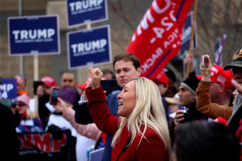 La representante estadounidense Marjorie Taylor Greene (R-GA) dirige a la multitud en un cántico a favor del expresidente de Estados Unidos y candidato presidencial republicano Donald Trump mientras llega a saludar a sus partidarios en un colegio electoral el día de las elecciones primarias presidenciales de Nuevo Hampshire, en Londonderry, Nuevo Hampshire, Estados Unidos