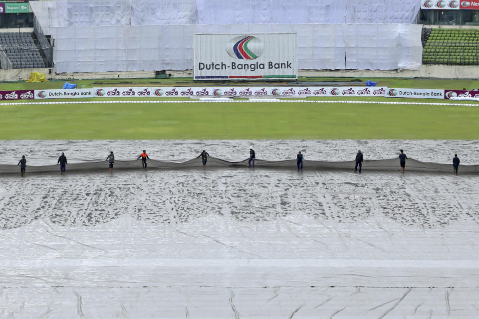 Groundsmen remove covers from the field on the third day of the second test cricket match between Bangladesh and New Zealand in Dhaka, Bangladesh, Friday, Dec. 8, 2023. (AP Photo/Mosaraf Hossain)