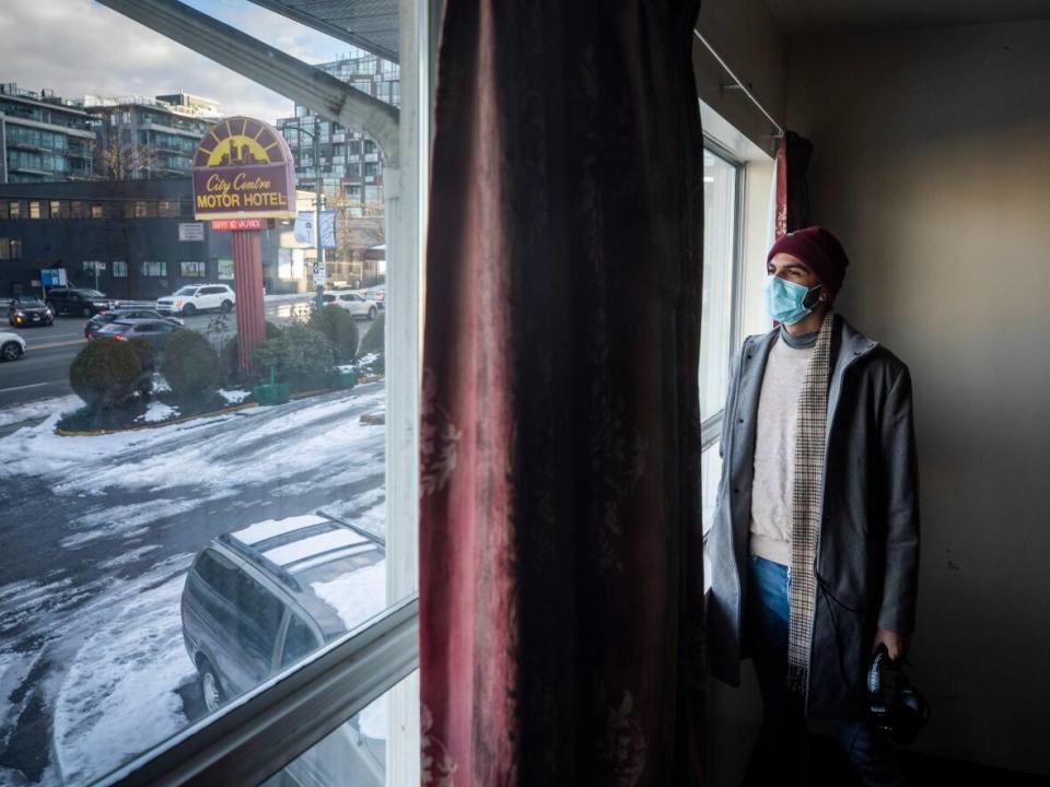 Artist Shehzar Abro looks out from his new room in the artist spaces at the City Centre Motor Hotel in Vancouver, British Columbia on Friday, Jan. 7, 2022.  (Ben Nelms/CBC - image credit)