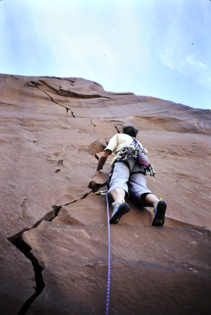 Rock climber climbing a crack in Utah Canyonlands.