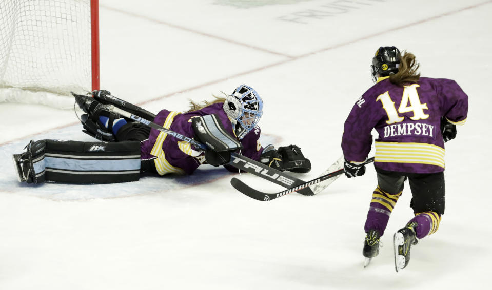 FILE- In this Feb. 10, 2019, file photo, Team Stecklein goalie Nicole Hensley, left, dives on the puck as Jillian Dempsey, right, watches for the rebound in the first period of the NWHL All-Star Hockey Game in Nashville, Tenn. The women's hockey league thinks it can make it work with the same kind of COVID-19 testing the NBA used in its Disney World bubble. Players, coaches and staff will essentially be limited to hotel and Herb Brooks Arena, the site of the 1980 “Miracle on Ice” that serves as a historic setting for a unique season. (AP Photo/Mark Humphrey, File)