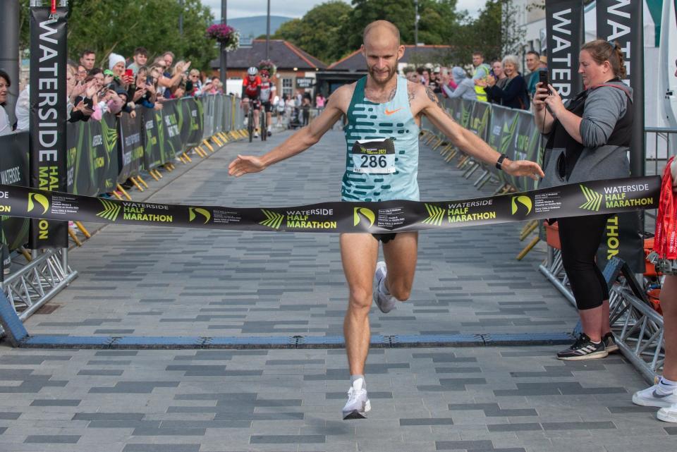 Kyle Doherty begins his celebrations as he claims the 2023 Waterside Half Marathon Mens title on Sunday. Picture Martin McKeown. 03.09.23
