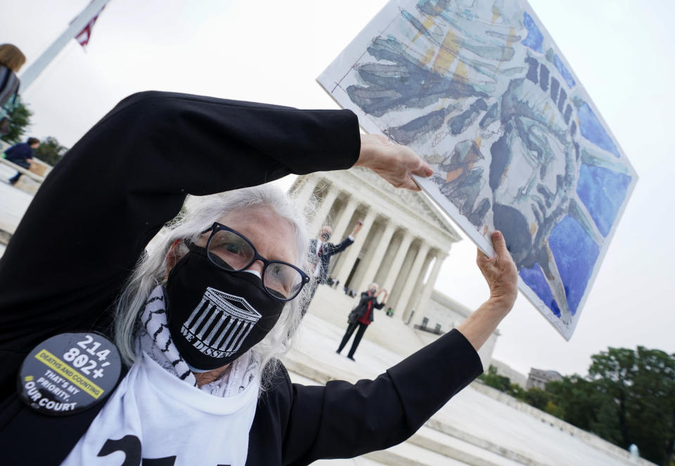 A demonstrator holds a sign in protest of the Senate Judiciary Committee hearing for U.S. Supreme Court nominee Judge Amy Coney Barrett outside the Supreme Court in Washington, U.S., October 13, 2020.  REUTERS/Kevin Lamarque