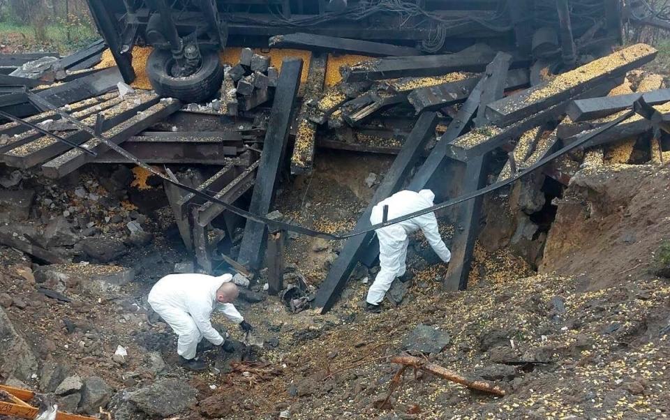 Experts look through the site where a Russian-made missile hit - Polish Police via AP