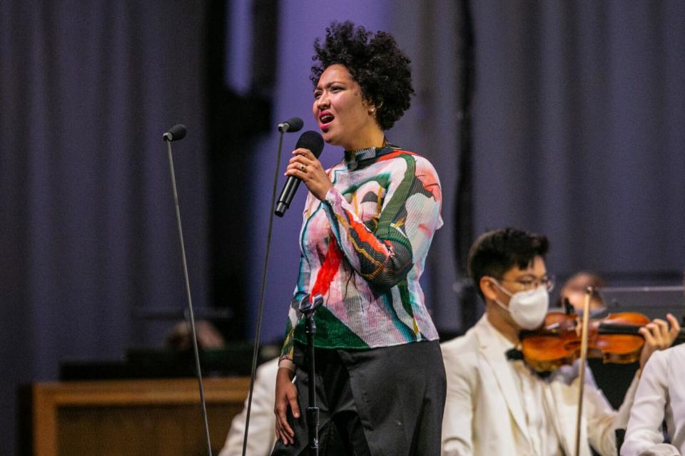 A woman sings onstage.