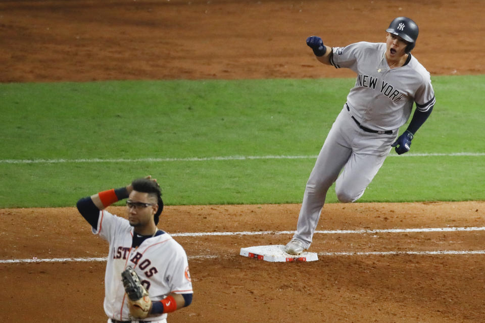 El colombiano Gio Urshela, de los Yanquis de Nueva York, recorre las bases, pasando junto al cubano Yuli Gurriel, tras conectar un jonrón en el primer juego de la Serie de Campeonato de la Liga Americana, el sábado 12 de octubre de 2019 (AP Foto/Sue Ogrocki)