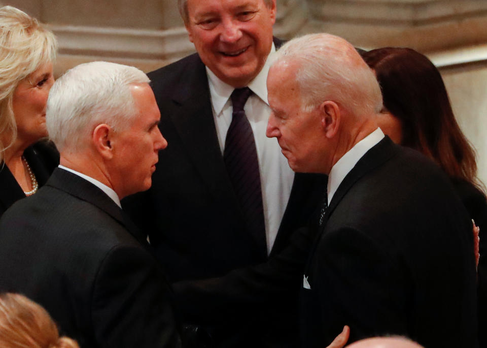 United States Vice President Mike Pence greets Former United States Vice President Joe Biden as they arrive for the funeral services for former United States President George H. W. Bush at the National Cathedral, in Washington, DC on Dec. 5, 2018.