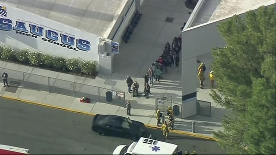 People are lead out of Saugus High School after reports of a shooting on Thursday, Nov. 14, 2019 in Santa Clarita, Calif.  The Los Angeles County Sheriff’s Department says on Twitter that deputies are responding to the high school about 30 miles (48 kilometers) northwest of downtown Los Angeles. The sheriff’s office says a male suspect in black clothing was seen at the school.  (KTTV-TV via AP)