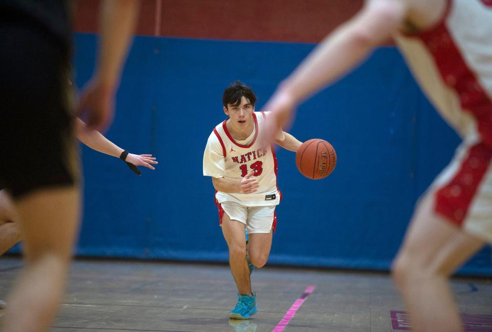 Natick High School senior captain Sean Fleming brings the ball up the court against Needham, Jan. 19, 2024.