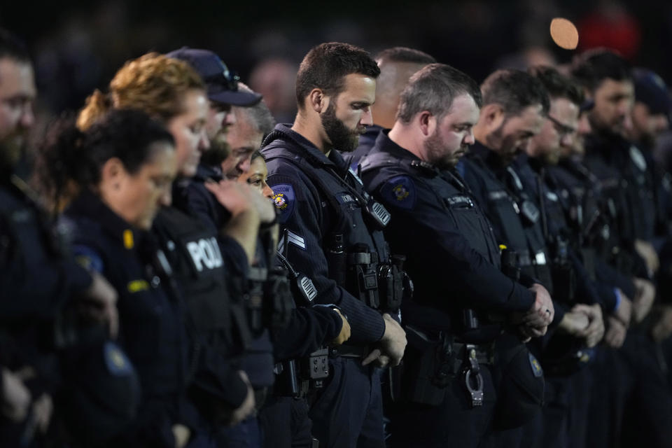 Lewiston Police officers stand during a moment of silence for the victims of the Lewiston shooting, Wednesday, Nov. 1, 2023, prior to a high school football game between Lewiston High School and Edward Little High School in Lewiston, Maine. Locals seek a return to normalcy after the mass shooting on Oct. 25. (AP Photo/Matt York)