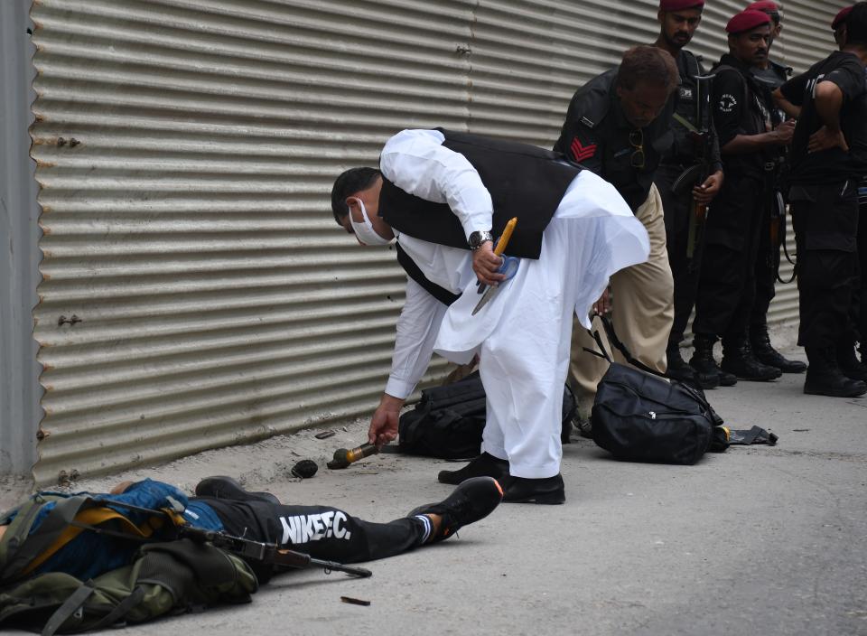 KARACHI, PAKISTAN - JUNE 29: Police officers inspect the site after gunmen attacked the Pakistani stock exchange building in Karachi, Pakistan on June 29, 2020. At least nine people were killed. The dead include four attackers, four Pakistan Stock Exchange security guards and a policeman, Muqaddas Haider, a city police chief, told reporters. At least seven people are also injured. (Photo by Sabir Mazhar/Anadolu Agency via Getty Images)