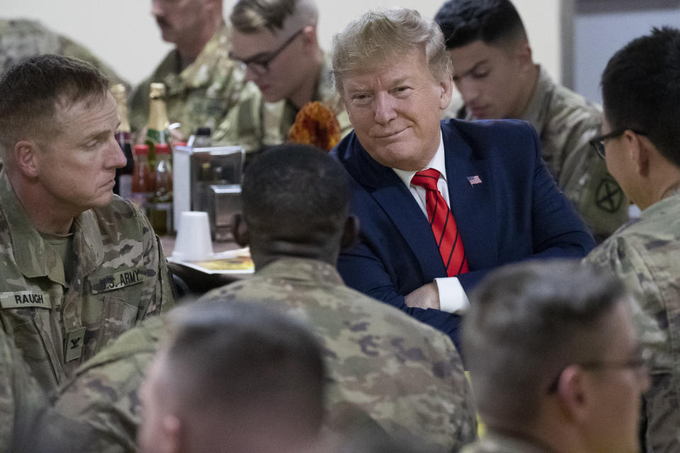 El presidente estadounidense Donald Trump sonríe sentado con soldados durante una visita sorpresiva por el Día de Acción de Gracias a las tropas en Afganistán, el jueves 28 de noviembre del 2019. (AP Foto/Alex Brandon)