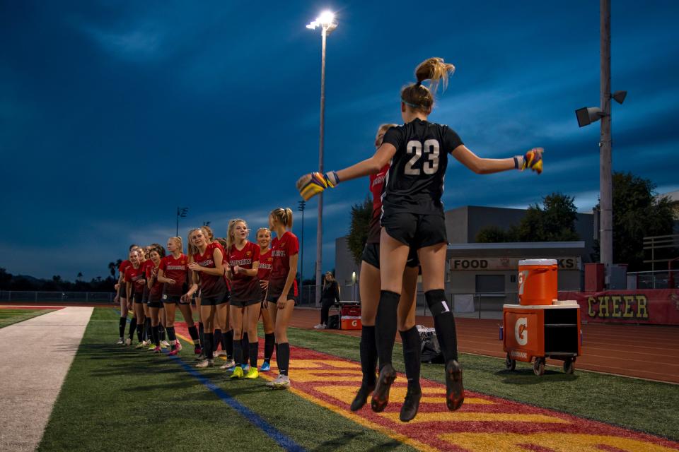 Players from Chaparral High School's varsity girls' soccer team do a chest bump before a home game against Red Mountain High School in Scottsdale on Jan. 13, 2022.