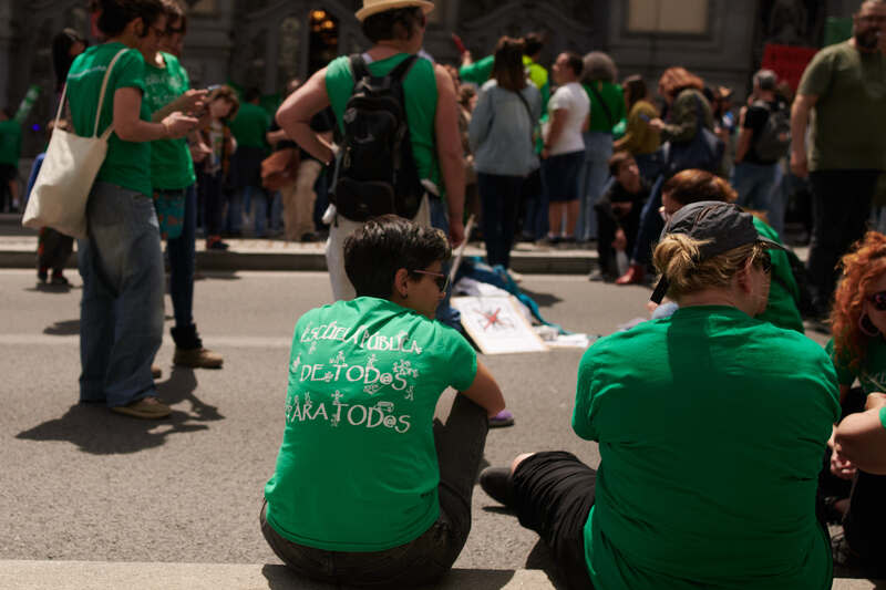 馬德里公立中小學教師罷課  綠色浪潮走上街頭 馬德里公立中小學逾5萬教師8日穿著綠色T恤走上街 頭示威抗議，被稱為「綠色浪潮」，圖左坐著的教師 身著的T恤背上寫著：「每個人的公立學校、所有人 的公共教育」。 中央社記者胡家綺馬德里攝  113年5月9日 