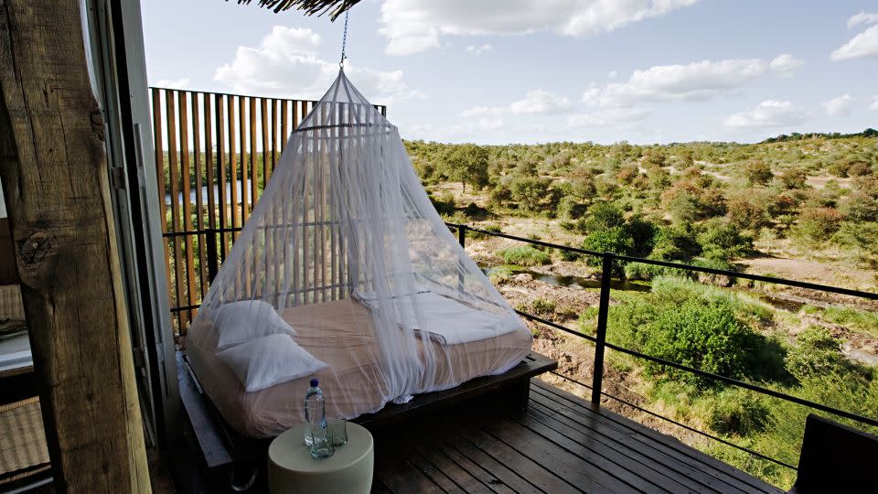 A mosquito net hanging over a day bed on the viewing deck of a luxury cliffside suite in South Africa. - Martin Harvey/The Image Bank Unreleased/Getty Images