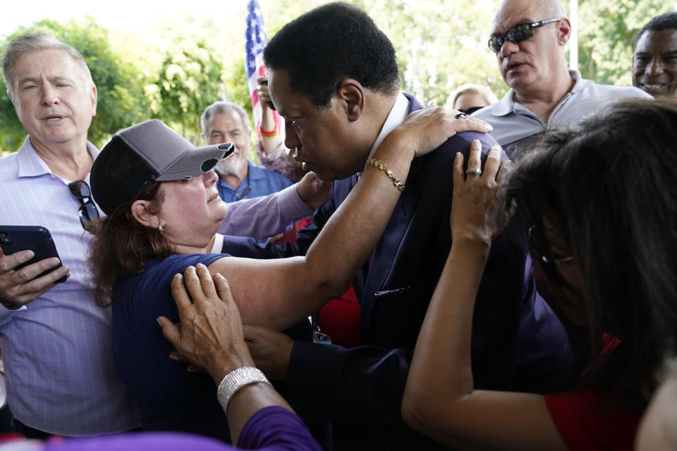FILE — On this July 13, 2021 file photo conservative radio talk show host Larry Elder center right, is hugged by supporter Paulette Melton during a campaign stop, Tuesday, in Norwalk, Calif. Elder, who is running to replace Democratic Gov. Gavin Newsom in the Sept. 14 recall election, says he would erase state vaccine and mask mandates, is critical of gun control, opposes the minimum wage and disputes the notion of systemic racism in America. (AP Photo/Marcio Jose Sanchez, File)