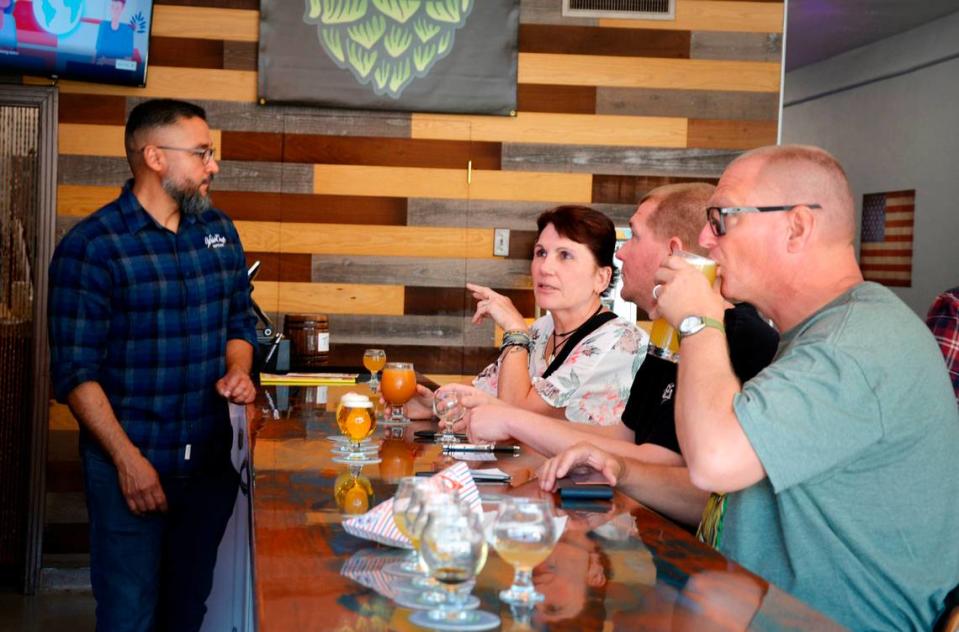 Tracy residents (L-R) Francie Pankratz, Justin Pankratz and Cory Pankratz taste the beers at WhichCraft, a new craft brew taproom in downtown Gustine, as co-owner Sam De La Cruz looks on May 19, 2013. C