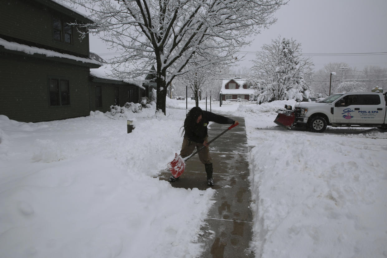 Jesse Sulham, 24, of Wolcott, Vt., shovels a sidewalk in Stowe, Vt., on Tuesday March 14, 2023. Sulham described the snow as wet and heavy; and he said the shoveling "'gave me reason to be in a good mood." Sulham was shoveling the day a winter storm snarled highways, led to hundreds of school closings, canceled flights and caused thousands of power outages in parts of the Northeast on Tuesday. (AP Photo/Wilson Ring)