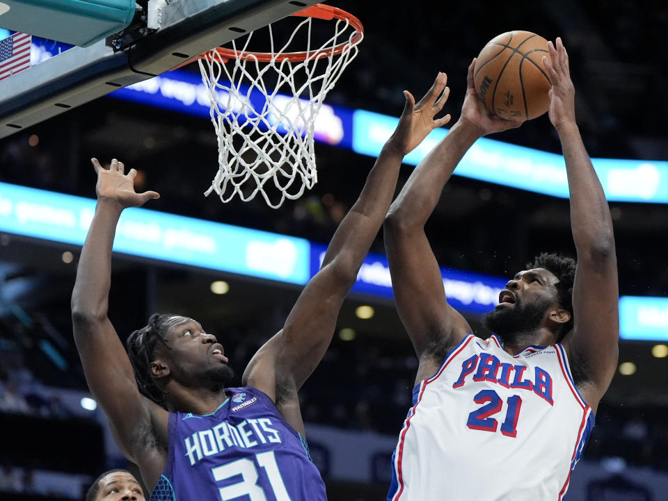 Philadelphia 76ers center Joel Embiid shoots over Charlotte Hornets center Nathan Mensah during the second half of an NBA basketball game on Saturday, Jan. 20, 2024, in Charlotte, N.C. (AP Photo/Chris Carlson)