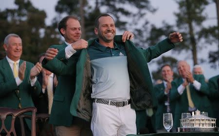 Sergio Garcia of Spain smiles as he is presented the green jacket by last year's champion, Danny Willett of England, after Garcia won the 2017 Masters golf tournament in a playoff at Augusta National Golf Club in Augusta, Georgia, U.S., April 9, 2017. REUTERS/Mike Segar