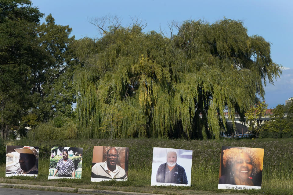 A procession of vehicles drive past photos of Detroit victims of COVID-19, Monday, Aug. 31, 2020 on Belle Isle in Detroit. Families have a chance to take one last public look at their lost loved ones in the nation's first citywide memorial to honor victims of the pandemic. Mourners will join 14 consecutive funeral processions to drive past nearly 900 large poster-sized photos of their loved ones staked around the island. (AP Photo/Carlos Osorio)