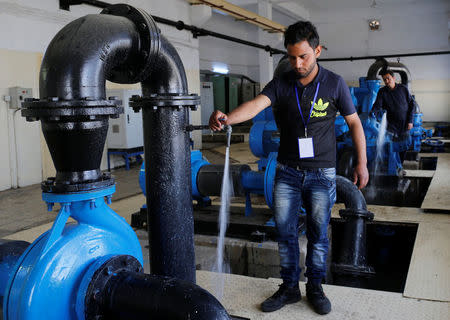 Employees work at a water treatment plant on the outskirts of Qaraqosh, Iraq, May 7, 2017. Picture taken May 7, 2017. REUTERS/Danish Siddiqui