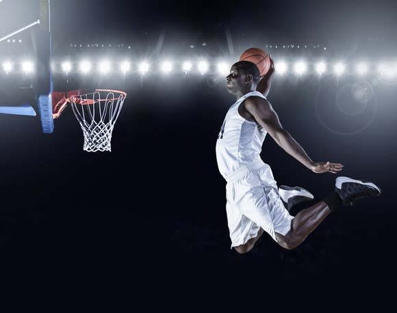 Basketball player dunking basketball.