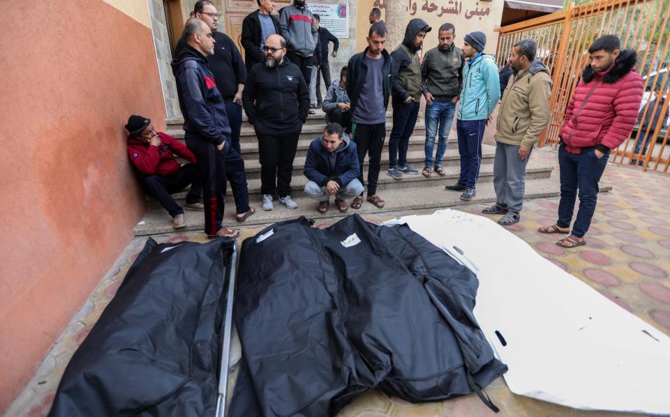 People mourn as they collect the bodies of Palestinians killed in an airstrike on December 23, 2023 in Khan Yunis, Gaza.