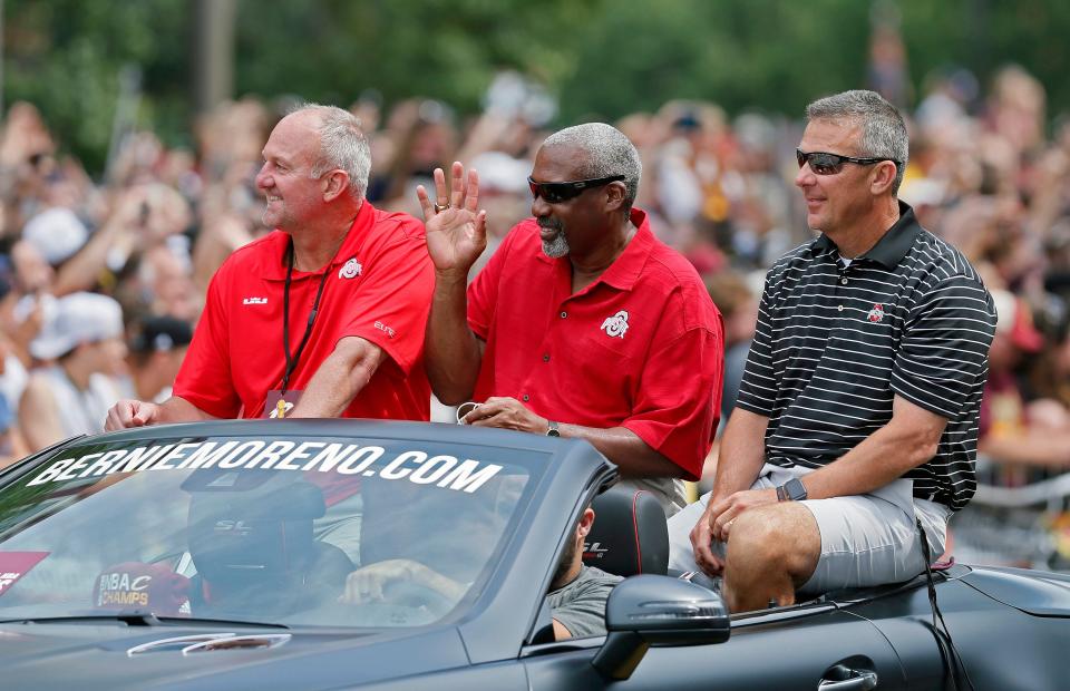 Ohio State men's basketball coach Thad Matta, athletic director Gene Smith and football coach Urban Meyer ride a car at the start of the NBA Championship parade in Cleveland on June 22, 2016.
