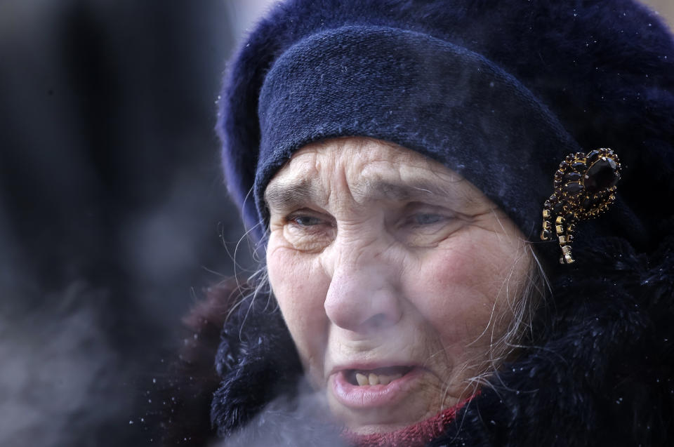 A woman reacts during prayers at the scene of the collapsed apartment building in Magnitogorsk, a city of 400,000 people, about 1,400 kilometers (870 miles) southeast of Moscow, Russia, Wednesday, Jan. 2, 2019. The building's pre-dawn collapse on Monday came after an explosion that was believed to have been caused by a gas leak. (AP Photo/Maxim Shmakov)