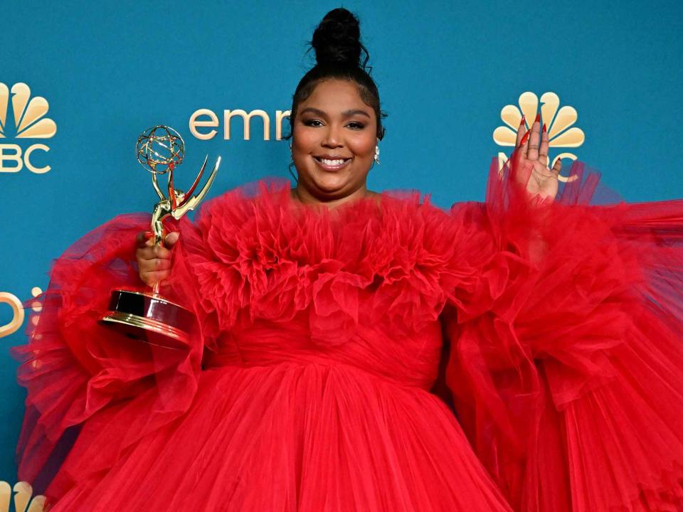 <p>Frederic J. Brown / AFP / Getty</p> Lizzo poses with the Emmy for Outstanding Competition Program for "Lizzo