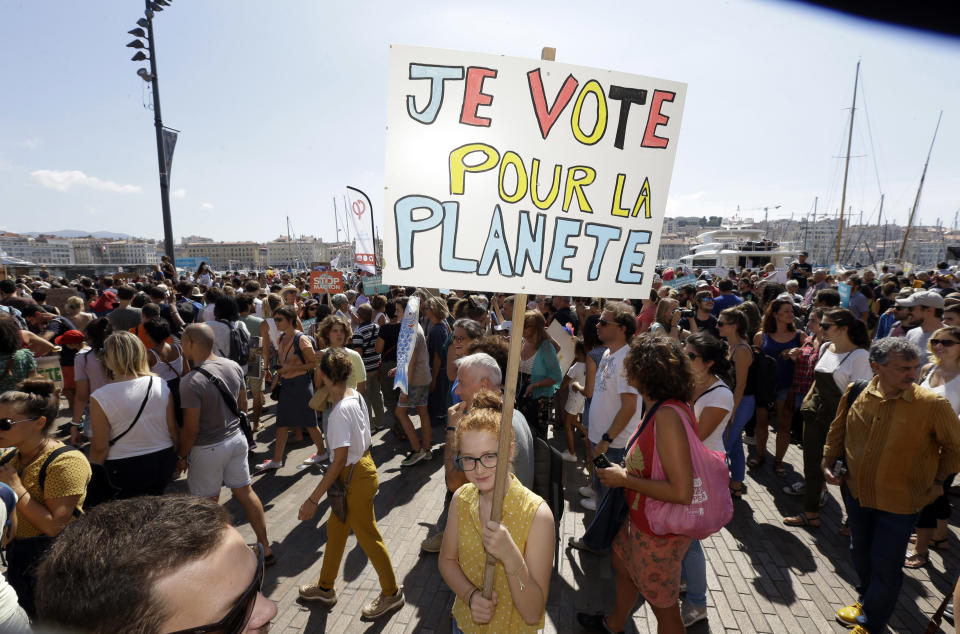 A person holds a placard reading "I vote for the planet", during a demonstration for the climate, in Marseille, southern France, Saturday, Sept. 8, 2018. Demonstrators in cities across France and Europe are marching on Saturday as part of a global day of protest ahead of a climate action summit later this month in San Francisco, USA. (AP Photo/Claude Paris)