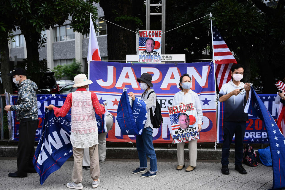 Image: Supporters of President Donald Trump wave flags as they hold a portrait of Secretary of State Mike Pompeo outside Japan's prime minister's office (Charly Triballeau / AFP - Getty Images)