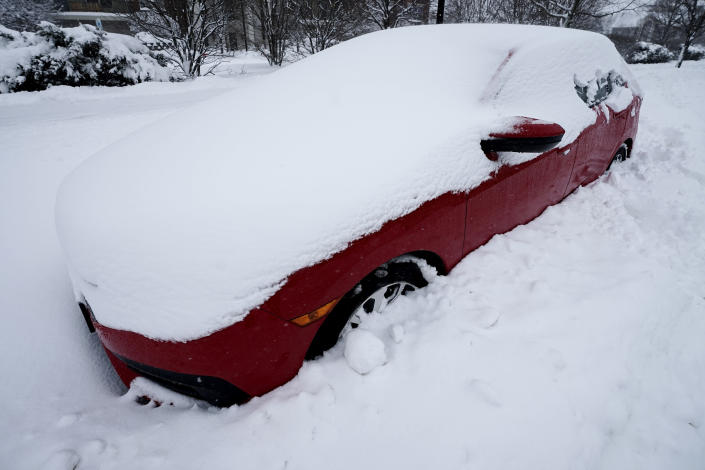 A car is covered by snow in Wheeling, Ill., Sunday, Jan. 31, 2021. Winter storm may leave more than 1 foot of snow in Chicago area before it's over, flight cancellations stack up, roads remain hazardous. (AP Photo/Nam Y. Huh)