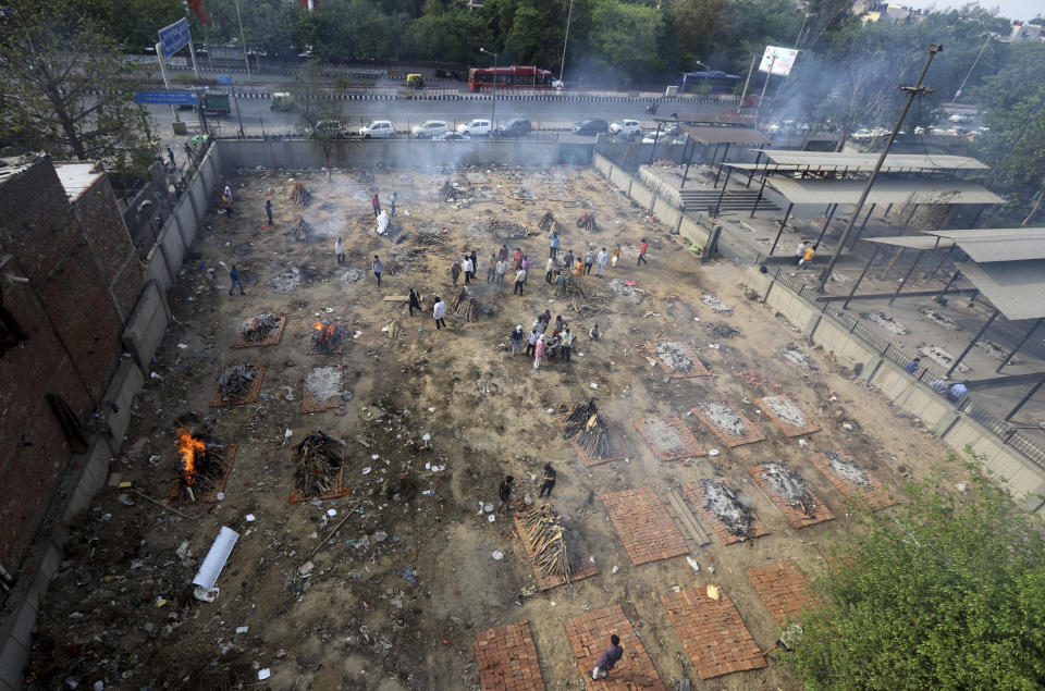 Multiple funeral pyres of those patients who died of COVID-19 disease are seen burning at a ground that has been converted into a crematorium for mass cremation of coronavirus victims, in New Delhi, India, Wednesday, April 21, 2021. (AP Photo)