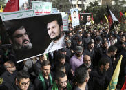 FILE - Lebanese Shiite supporters of the Iranian-backed Hezbollah group, hold portraits of Hezbollah leader Sayyed Hassan Nasrallah and Abdul-Malik al-Houthi, the leader of the Shiite Yemeni rebels, as they march during the holy day of Ashoura, in a southern suburb of Beirut, Lebanon, Oct. 12, 2016. Televised comments by George Kordahi, a Lebanon Cabinet minister about the war in Yemen exposed the depth of the crisis with Saudi Arabia, once a strong ally that poured millions and offered unwavering political support in this small Mediterranean nation. The crisis over veered into diplomatic isolation of Lebanon and threatens to split a new coalition government tasked with halting the country’s economic meltdown. (AP Photo/Hussein Malla, File)