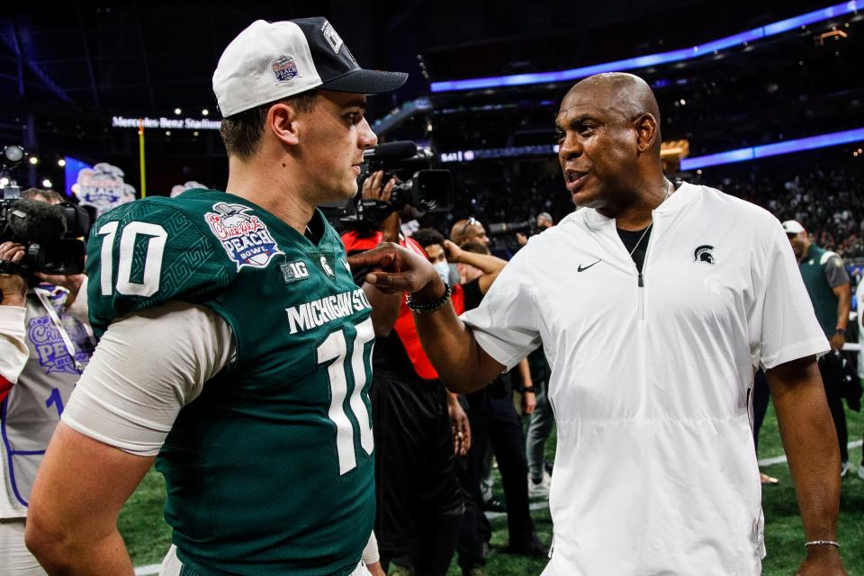 Michigan State coach Mel Tucker talks to quarterback Payton Thorne after the 31-21 win over Pittsburgh in the Peach Bowl at the Mercedes-Benz Stadium in Atlanta on Thursday, Dec. 30, 2021.