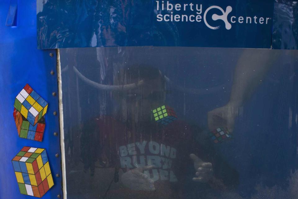 North American Speed Cube Champion Anthony Brooks attempts to break the Guinness World Records title for "Most Cubes Solved Underwater In One Breath" at the National Rubik's Cube Championship at Liberty Science Center in Jersey City