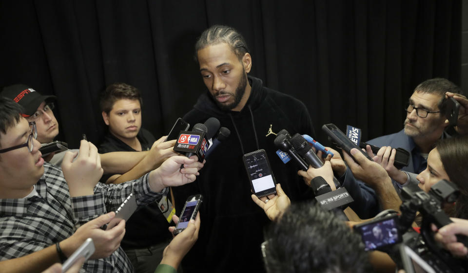 Reporters in San Antonio surround Spurs star Kawhi Leonard on Monday. (AP)