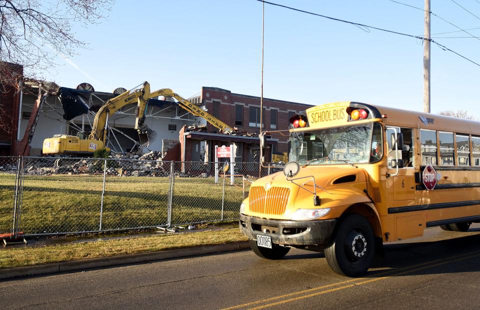 A Mansfield City Schools bus passes the former Creveling School, most recently known as Ocie Hill Neighborhood Center, as the building is being demolished.