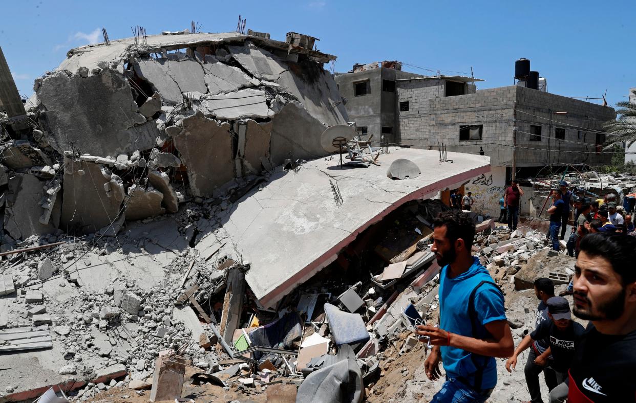 People inspect the rubble of a destroyed residential building that was hit by Israeli airstrikes, in Gaza City, Wednesday, May 12, 2021.